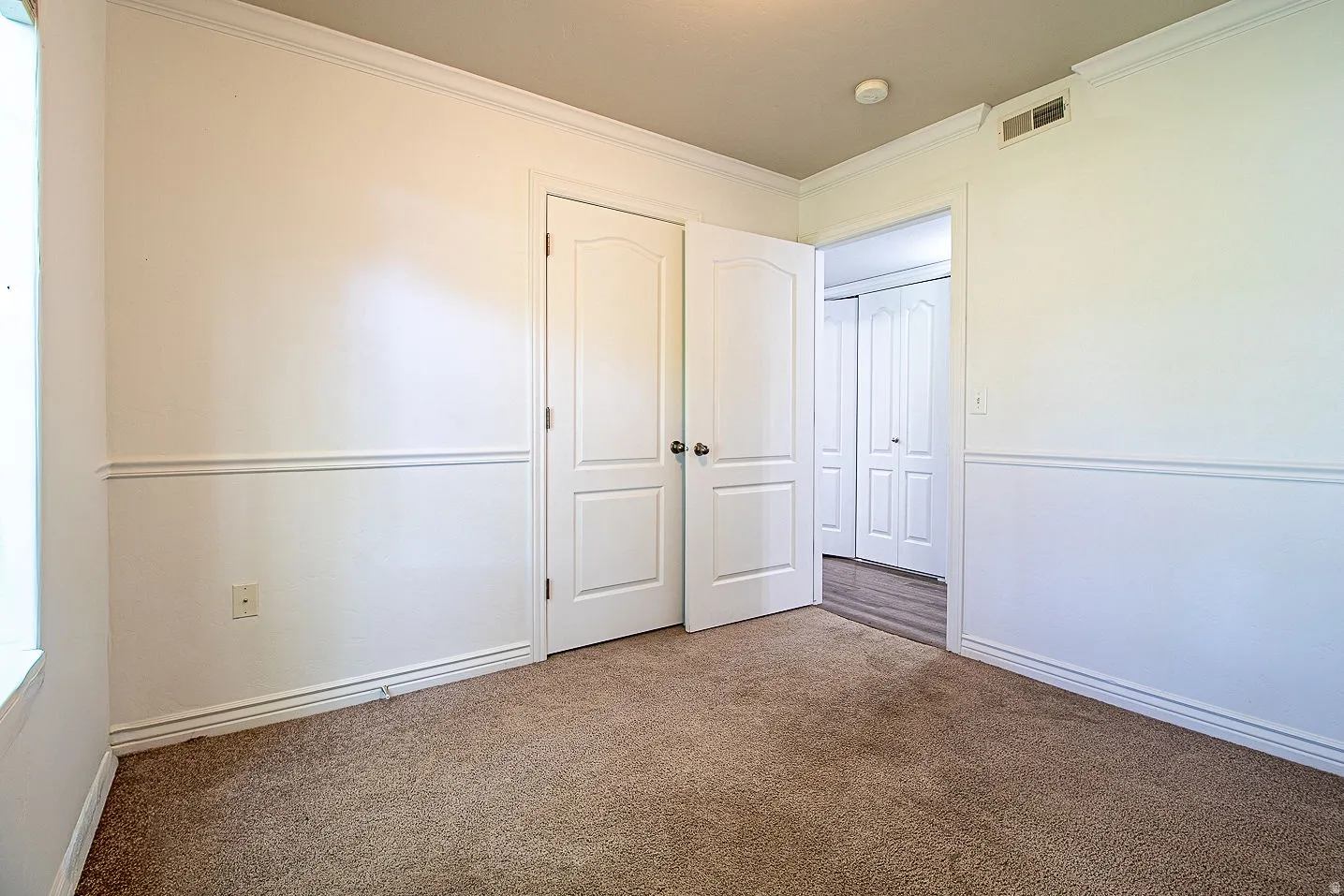 Unfurnished bedroom featuring carpet floors and crown molding