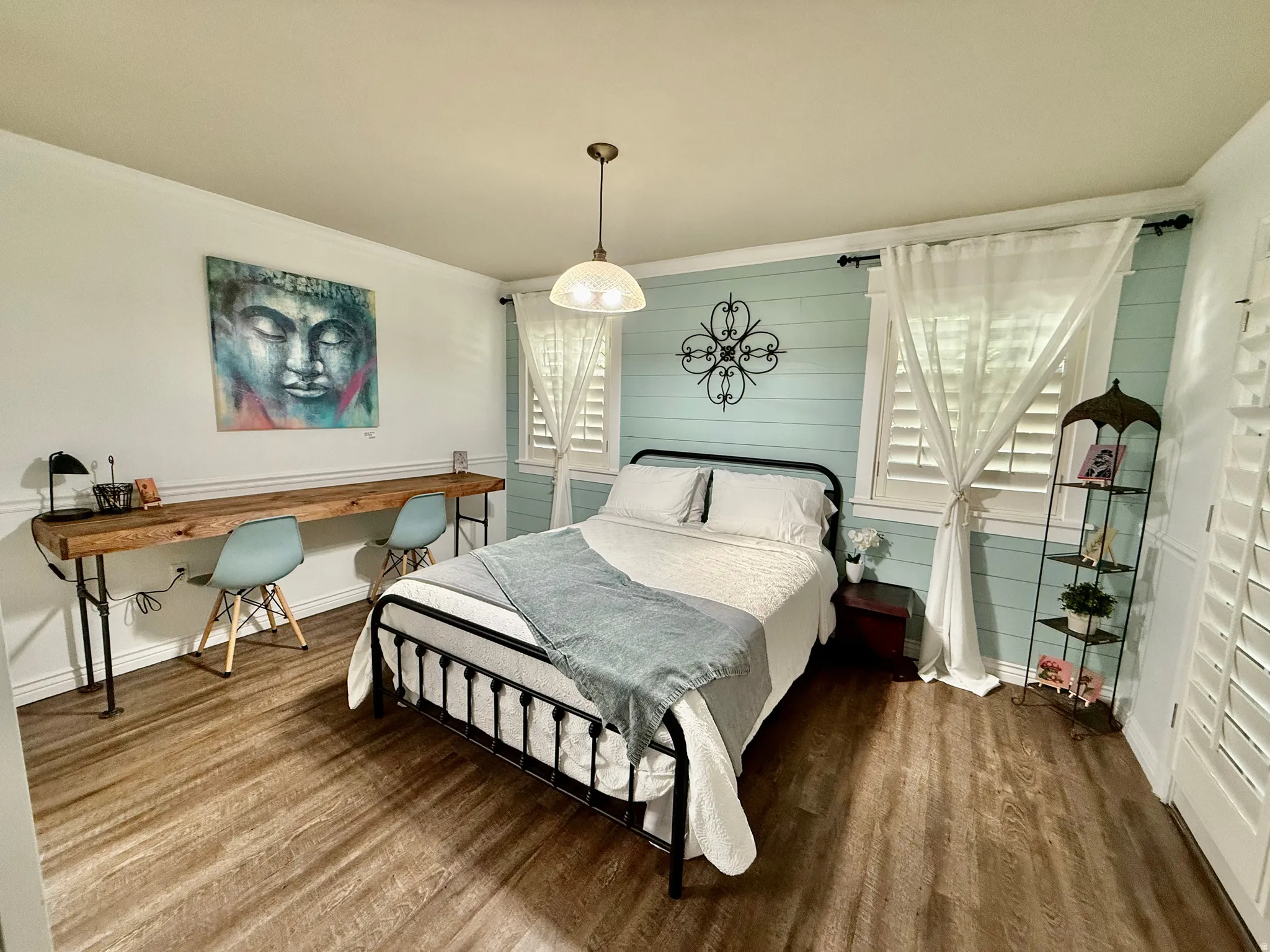 Bedroom featuring wood finished floors, ornamental molding, and an office area