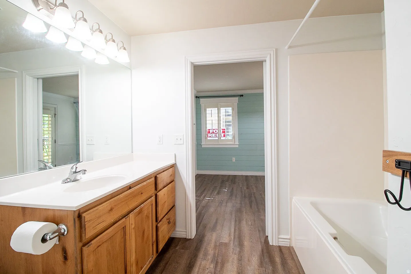 Full bathroom featuring vanity, dark wood-type flooring, and washtub / shower combination