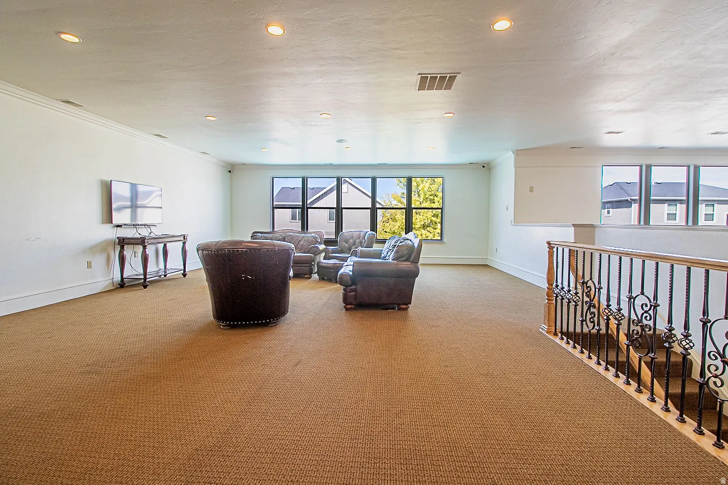 Living room with crown molding, light colored carpet, and recessed lighting