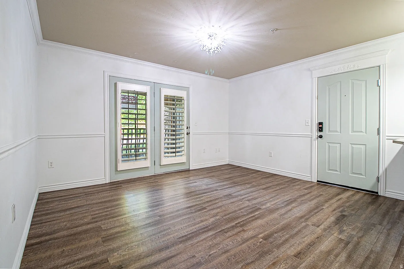 Spare room featuring dark wood-type flooring and ornamental molding