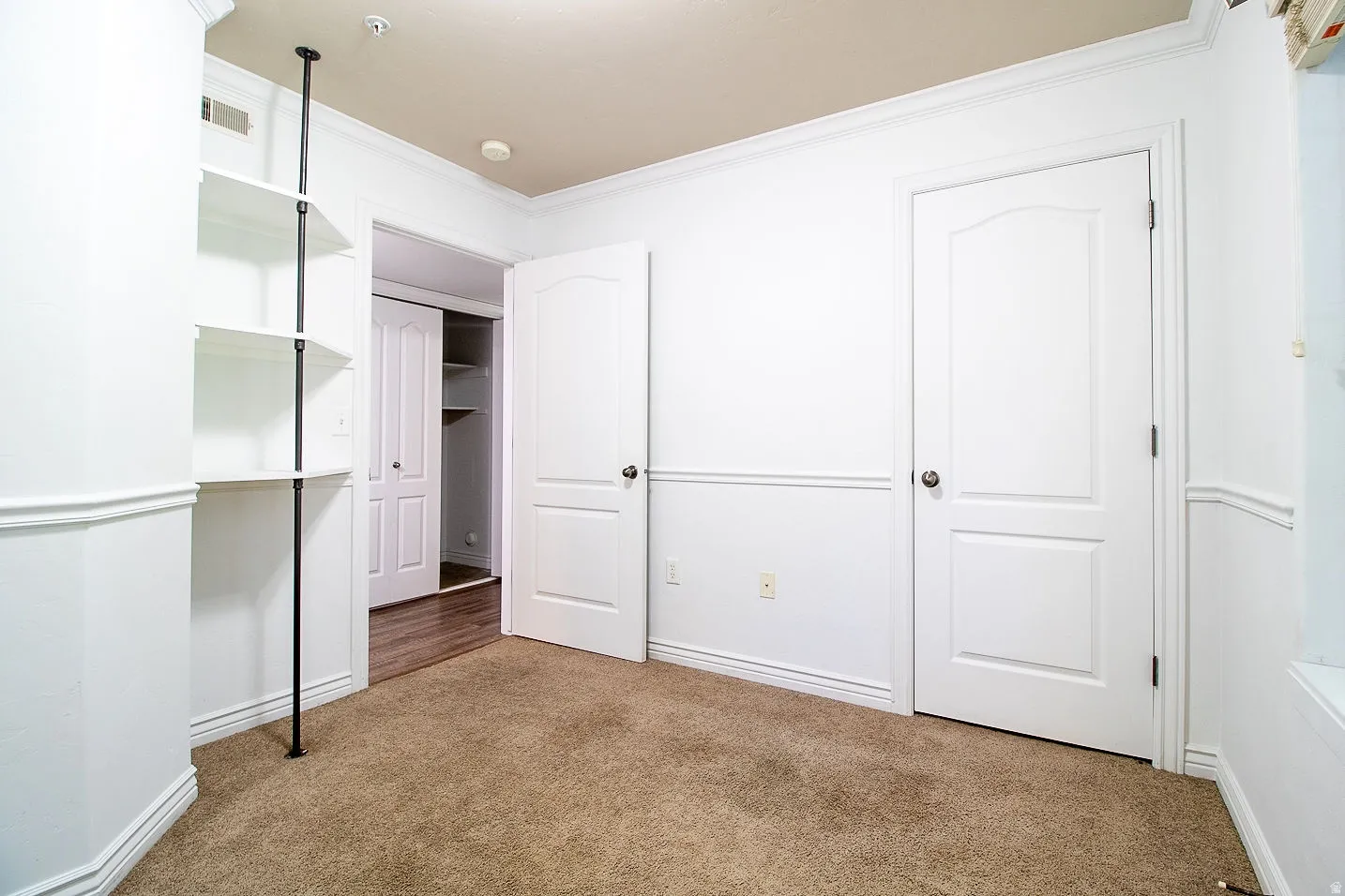 Unfurnished bedroom with carpet flooring and crown molding