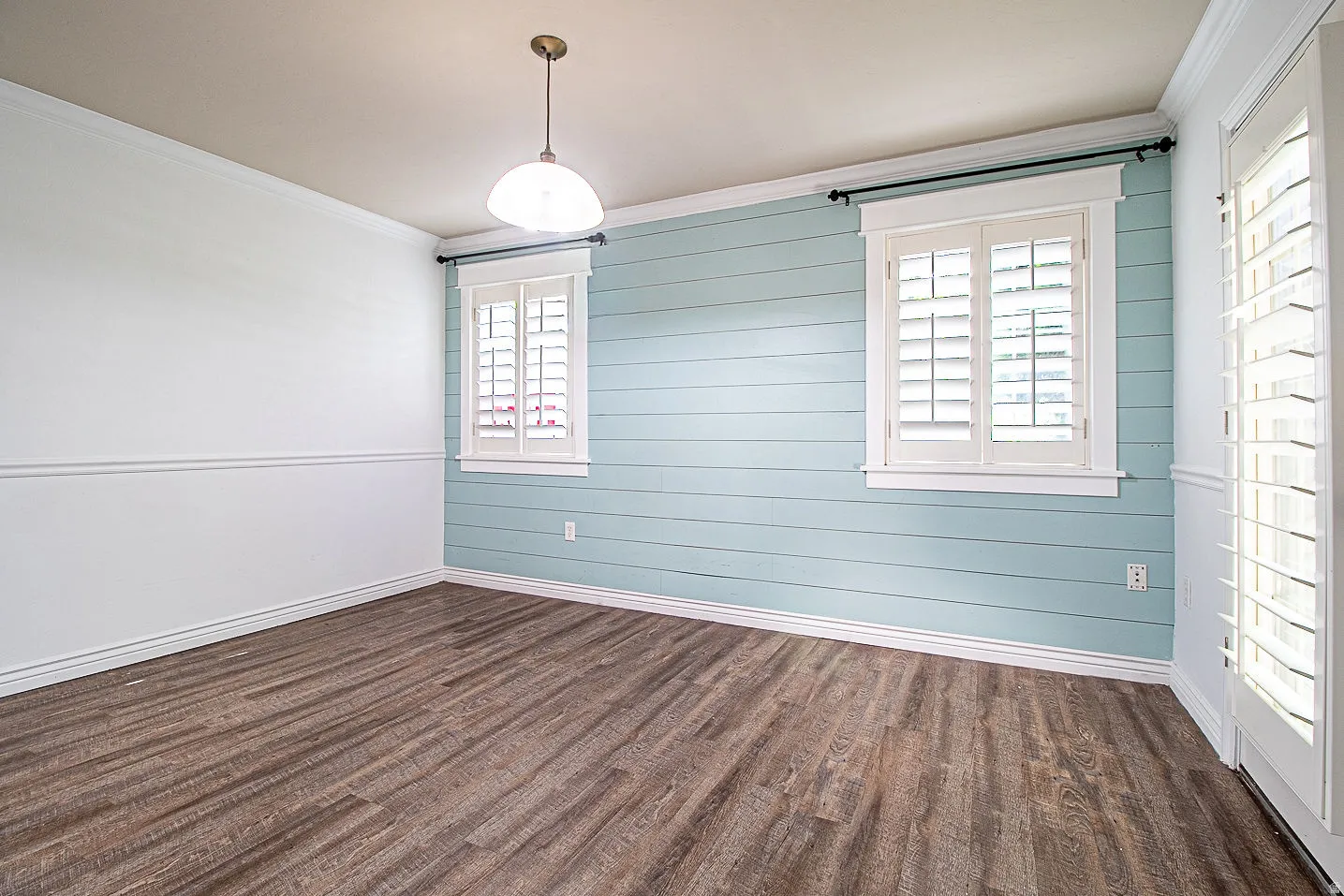Unfurnished dining area with crown molding and dark wood finished floors