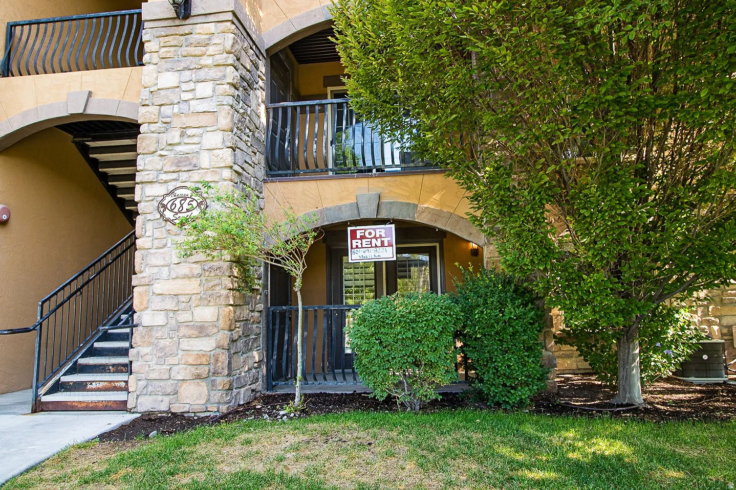 Property entrance featuring stone siding and stucco siding
