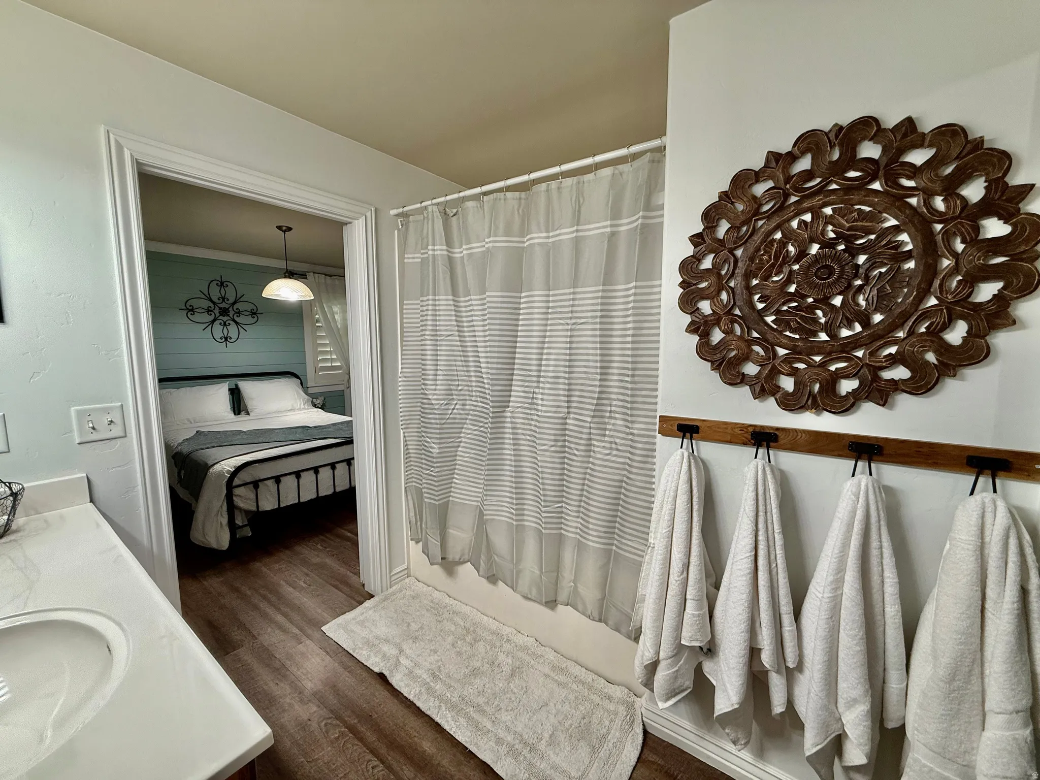 Ensuite bathroom featuring vanity, dark wood-type flooring, and a shower with shower curtain