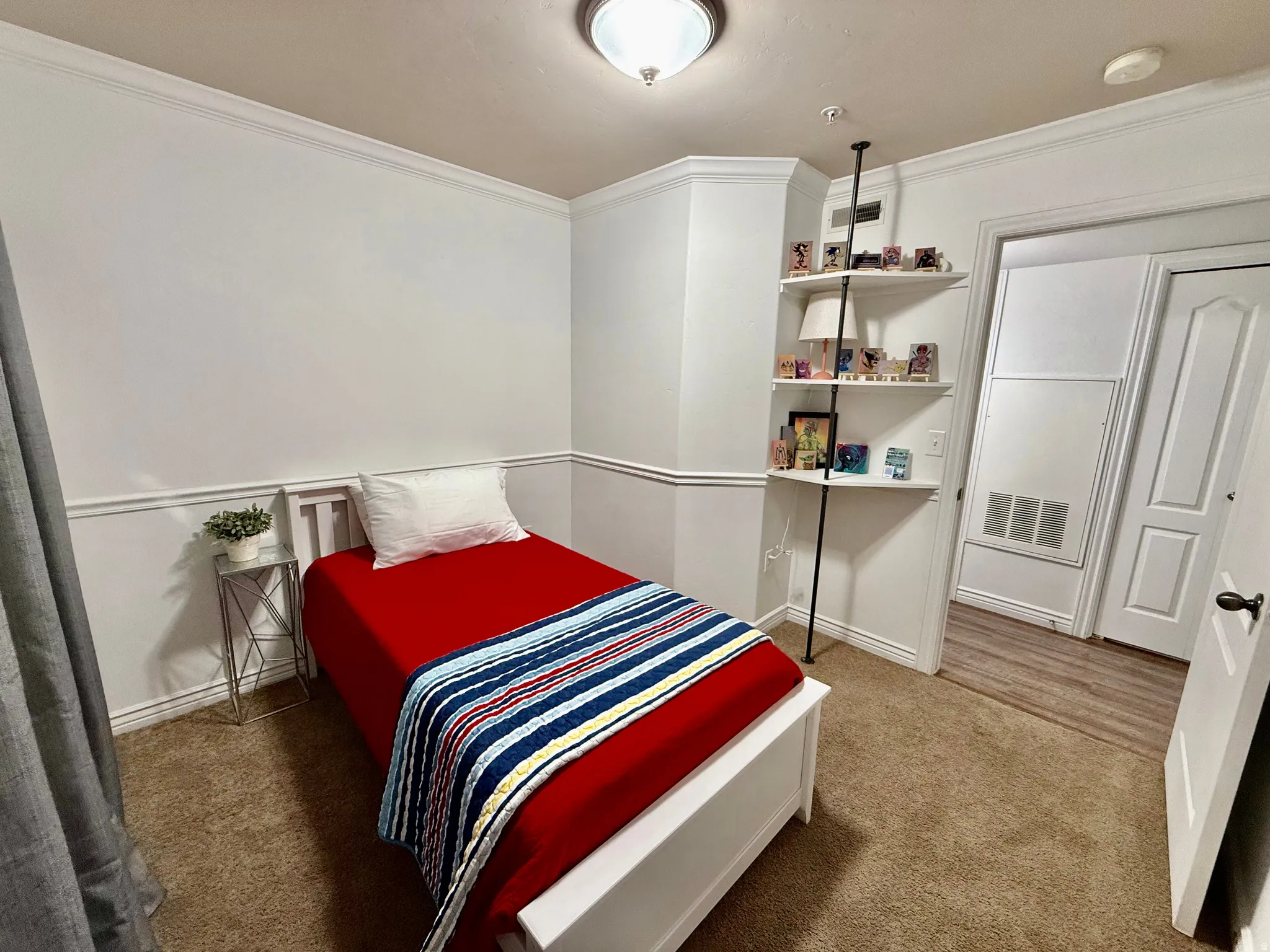 Bedroom with crown molding and light colored carpet