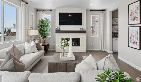 Living area with wood finished floors. Actual home to be built will not have the side windows or fireplace.  This is a rendering photo only. Actual home may have different finishes and features than those shown.
