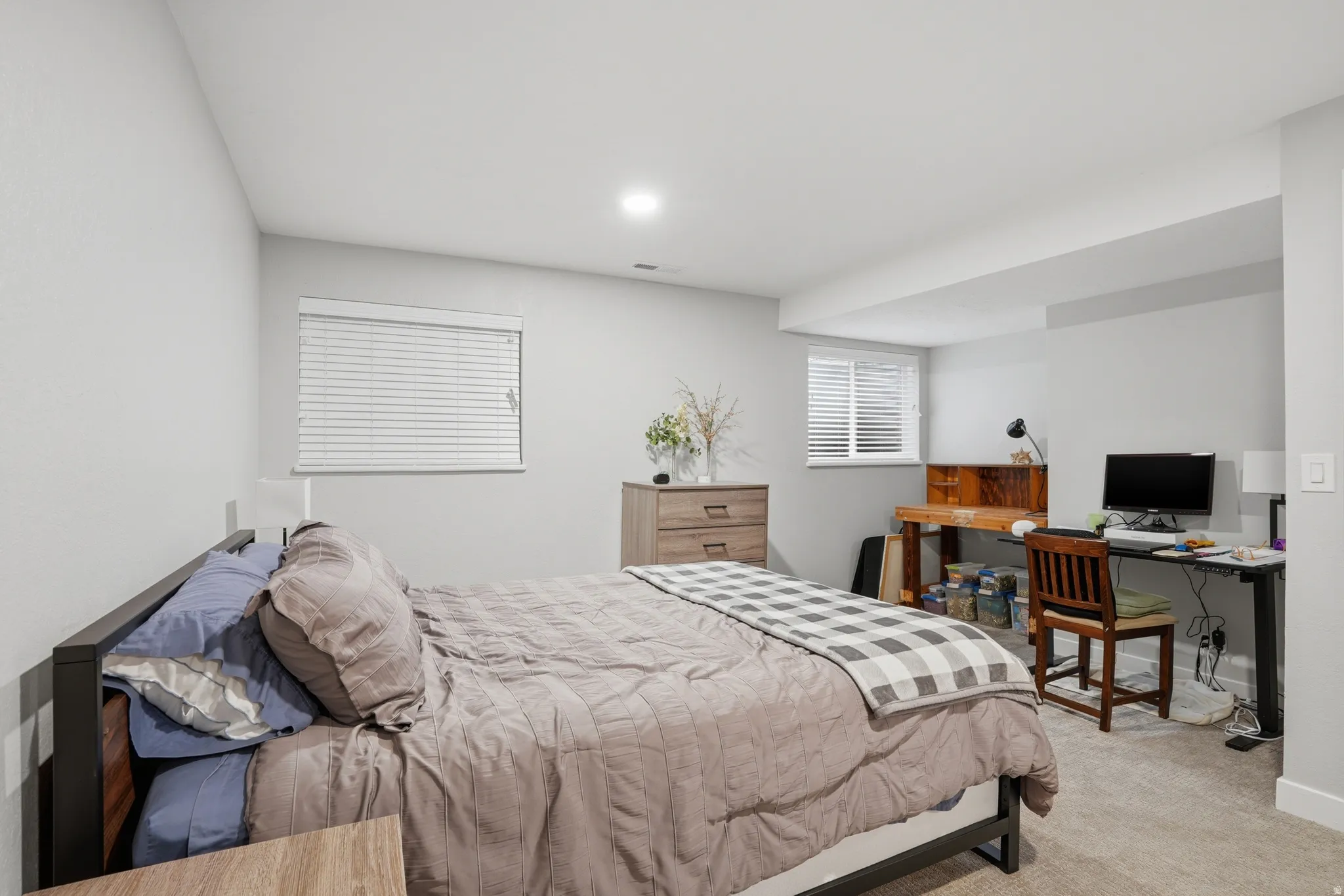 Bedroom with light carpet and a desk