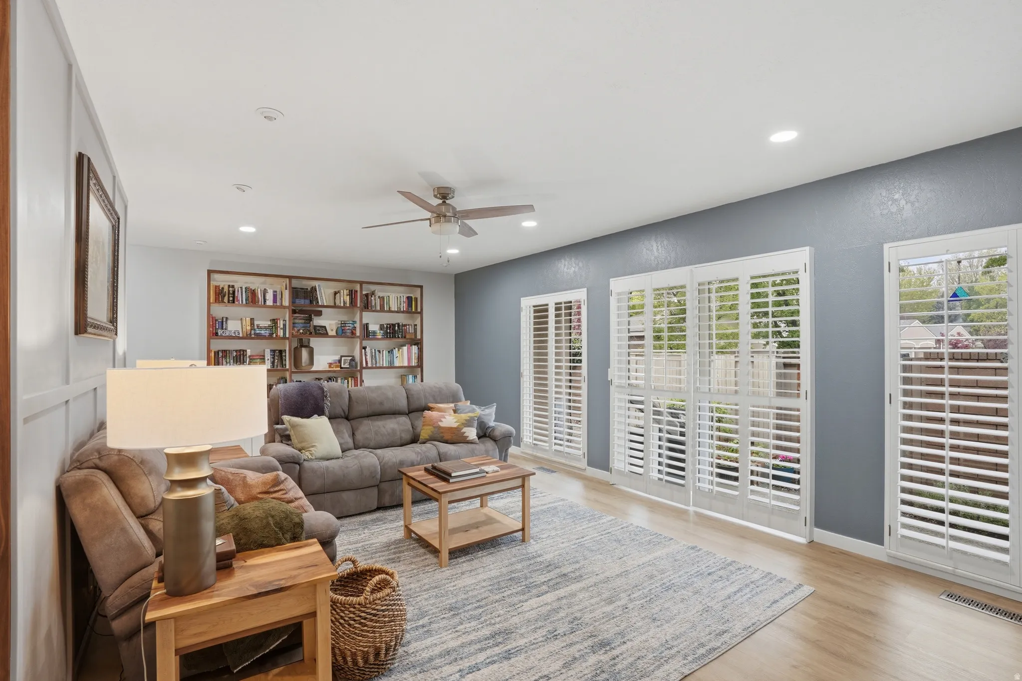 Living area with ceiling fan, light wood finished floors, and recessed lighting