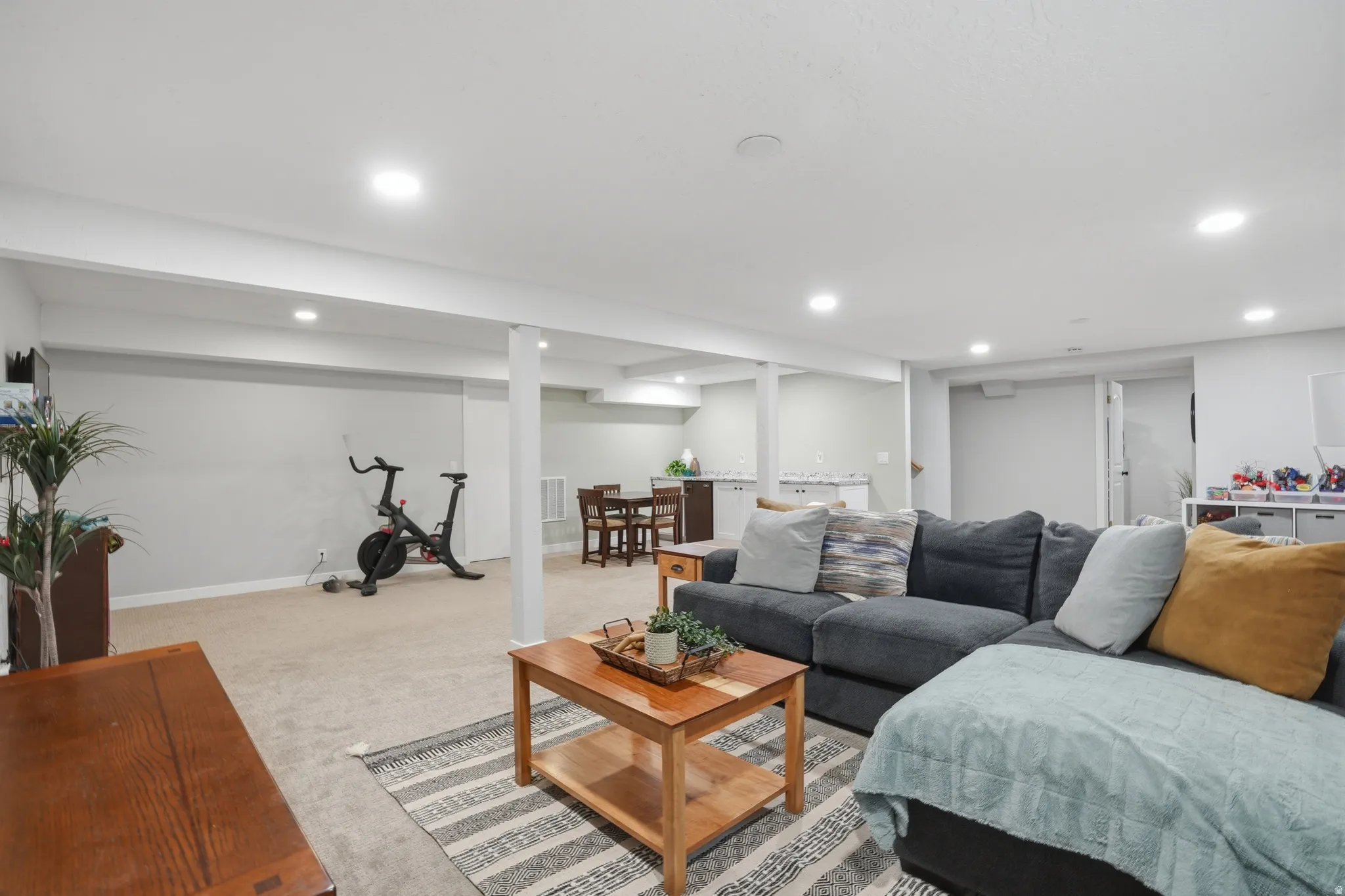 Living area featuring light carpet and recessed lighting