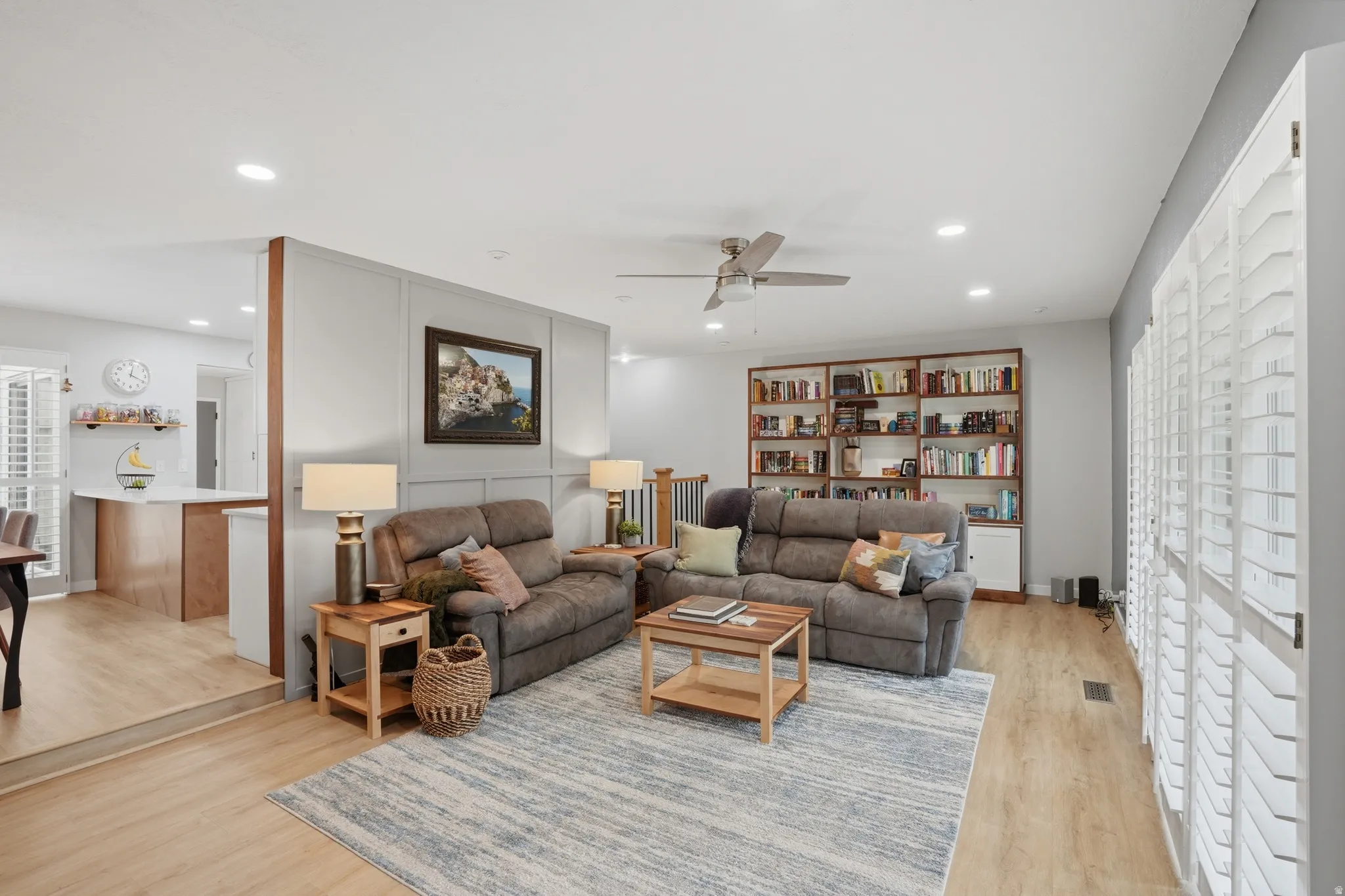Living area featuring plenty of natural light, a ceiling fan, light wood-style floors, and recessed lighting