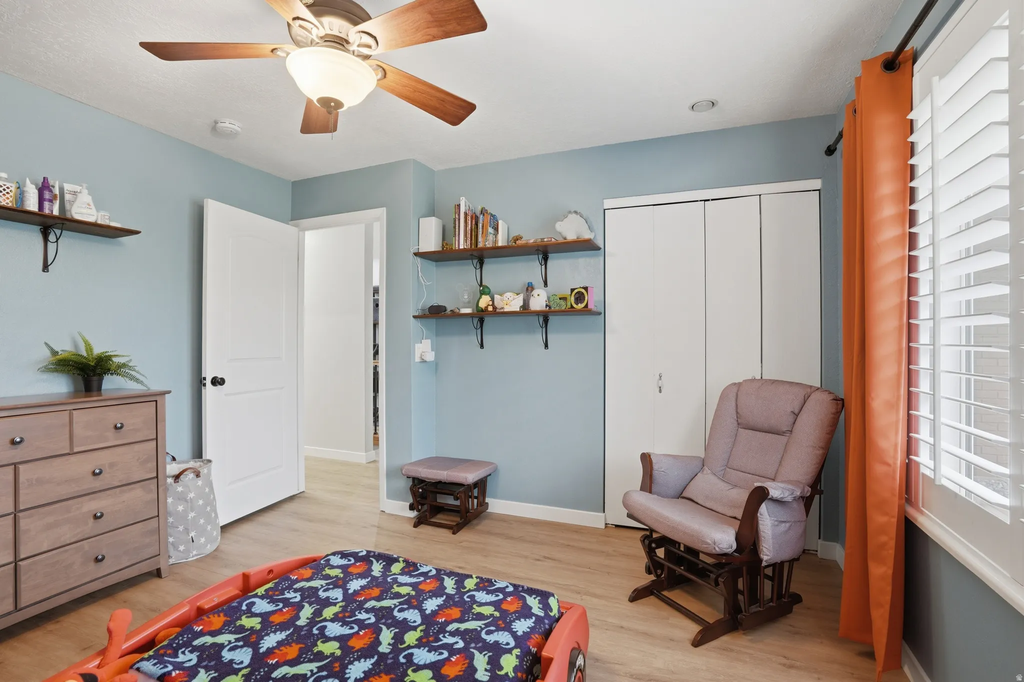 Bedroom featuring light wood-style floors, ceiling fan, and a closet