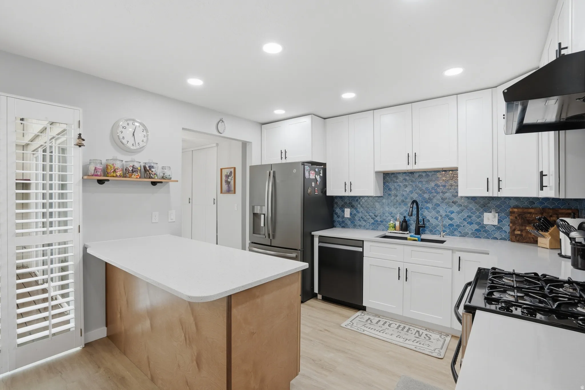 Kitchen featuring white cabinetry, a peninsula, light wood-style flooring, stainless steel appliances, and recessed lighting