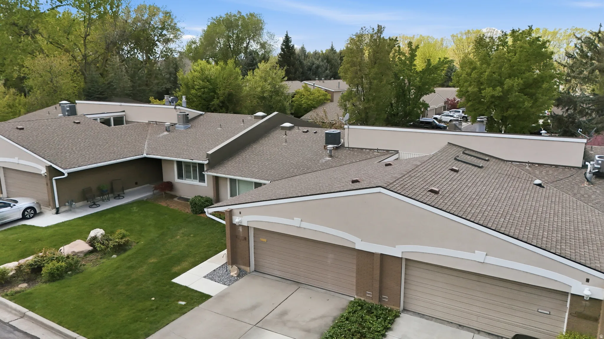 Aerial view of property and surrounding area featuring a tree filled landscape