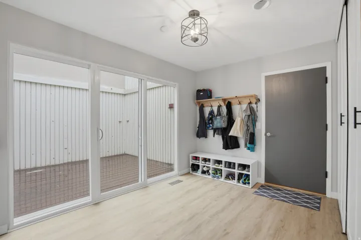 Mudroom with light wood finished floors and baseboards