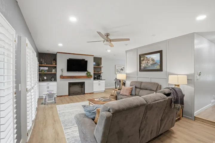 Living area featuring a ceiling fan, light wood-type flooring, recessed lighting, and a glass covered fireplace