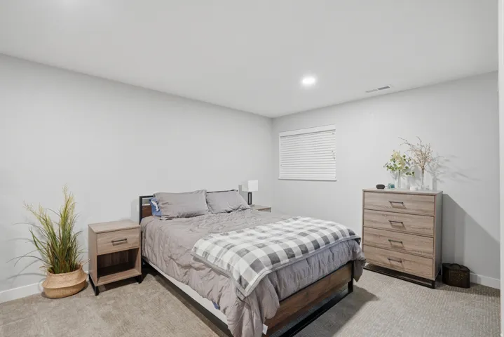 Bedroom with light carpet and recessed lighting