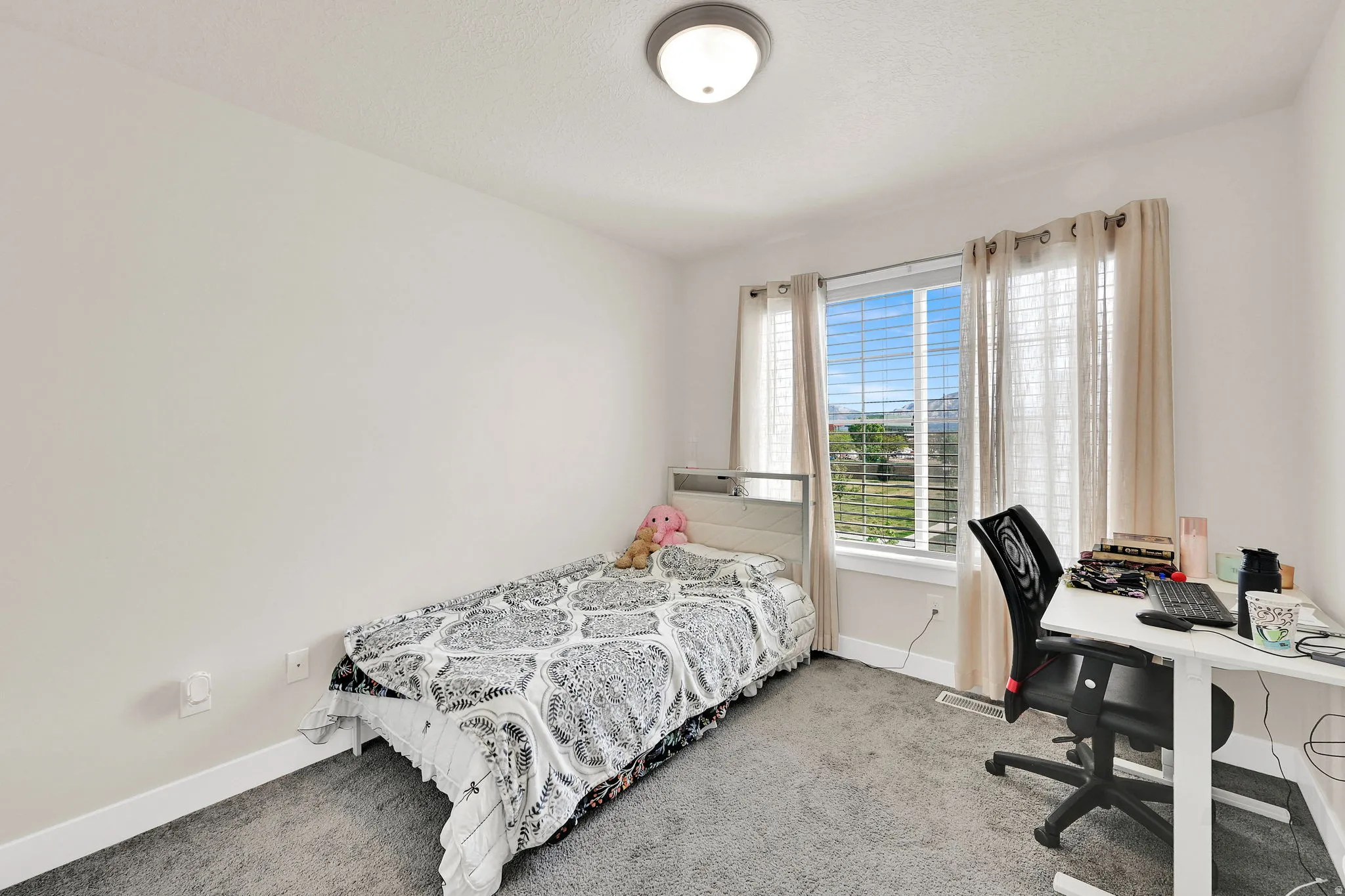 Bedroom featuring a desk and light colored carpet