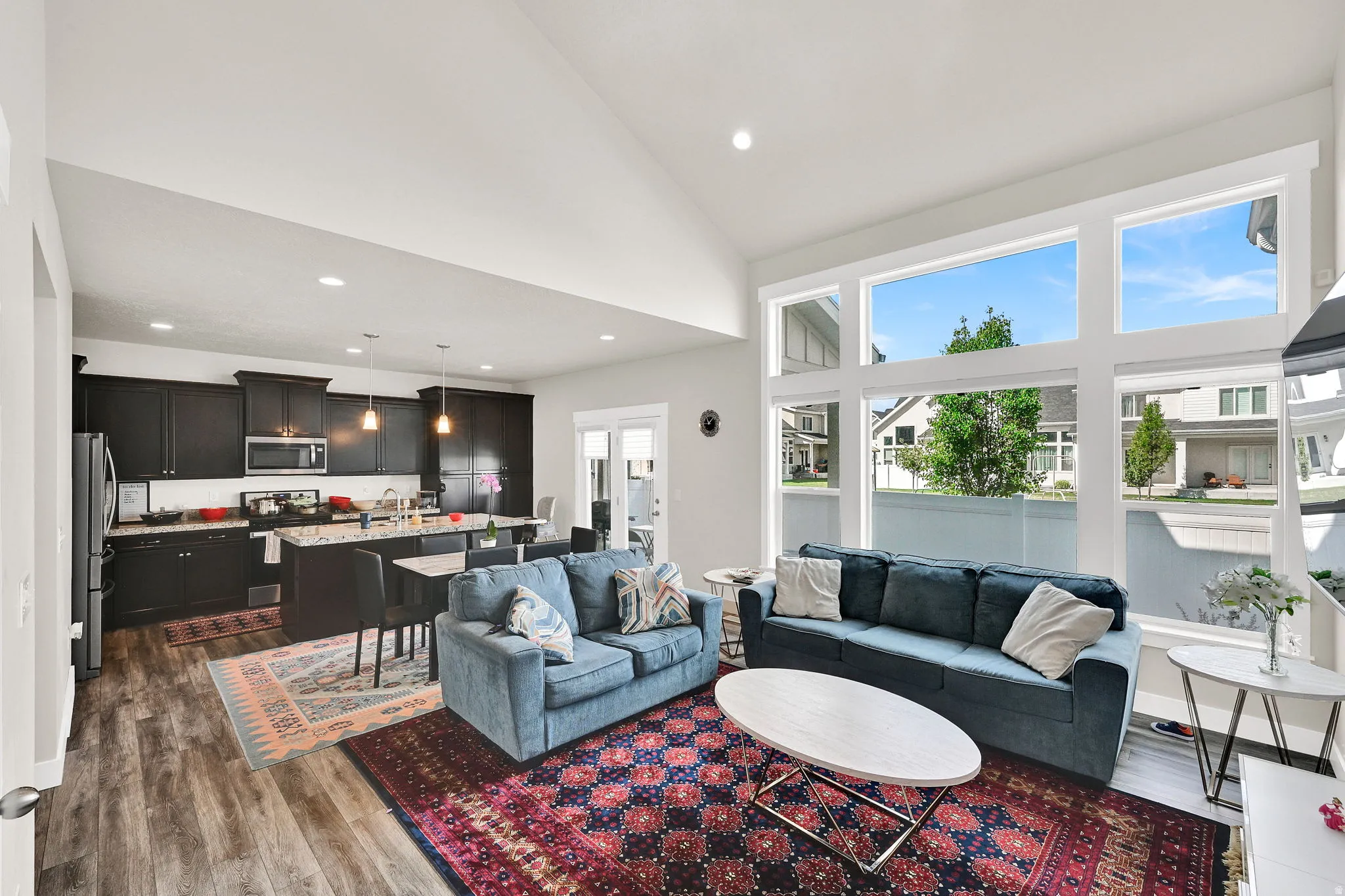 Living area featuring light wood finished floors, lofted ceiling, and recessed lighting
