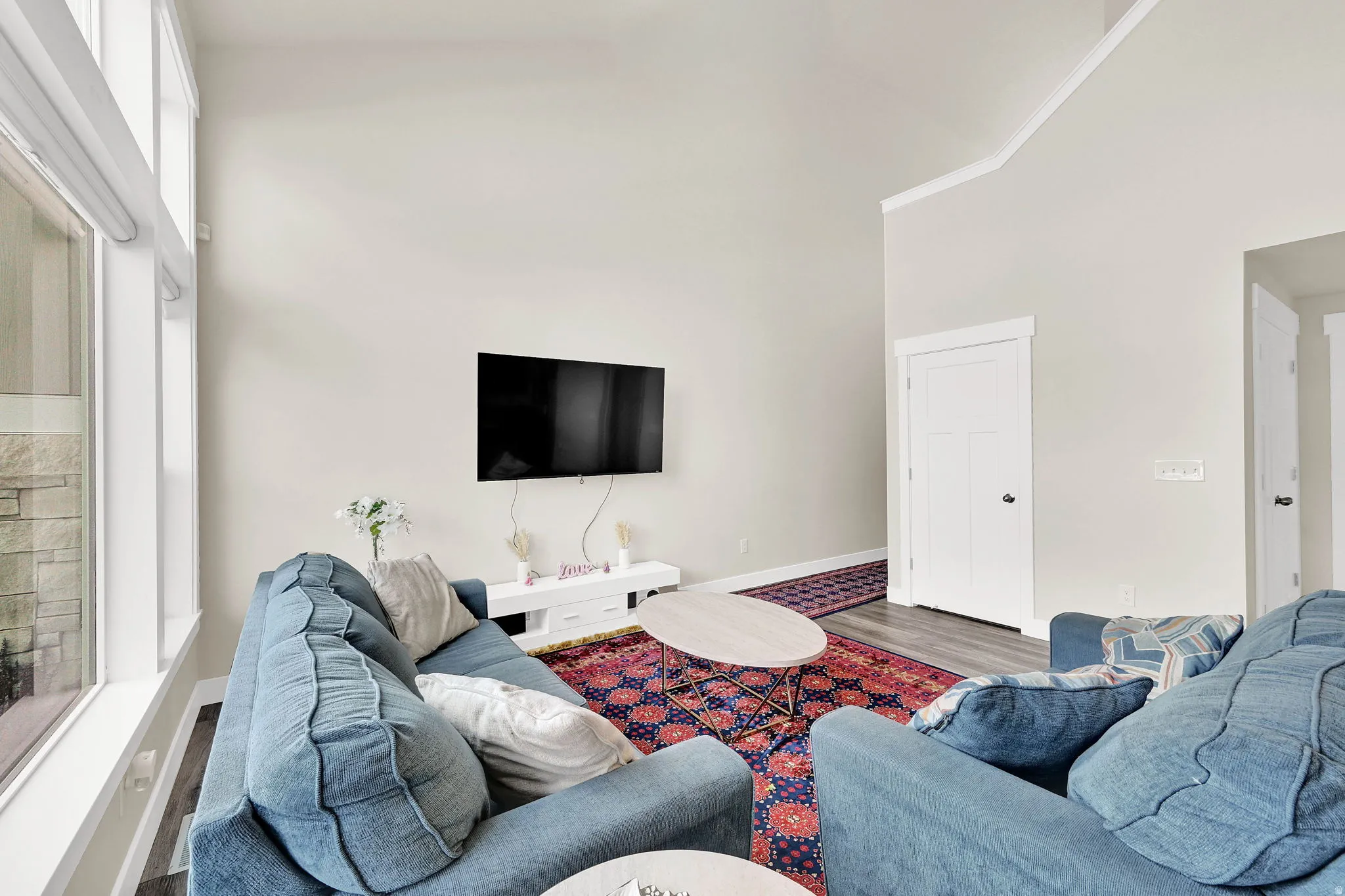 Living area featuring wood finished floors and a high ceiling