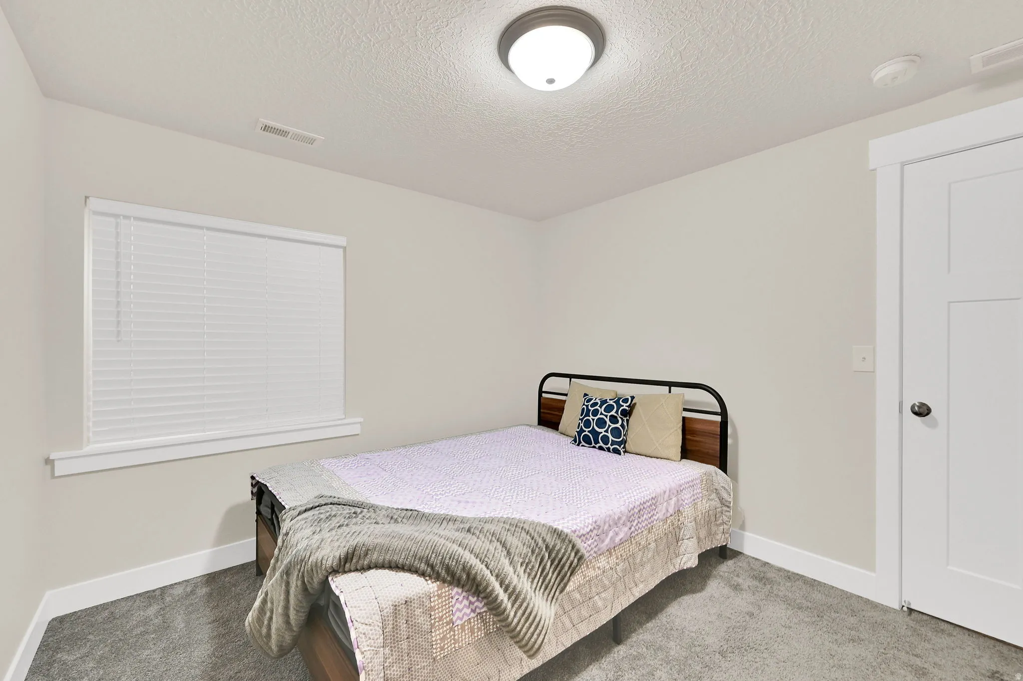 Bedroom with carpet flooring and a textured ceiling
