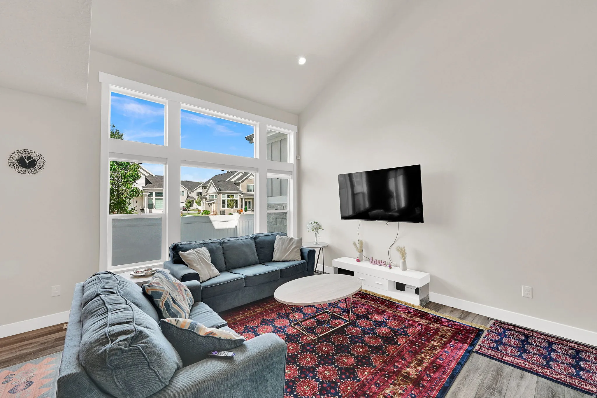 Living room featuring lofted ceiling, wood finished floors, and a residential view