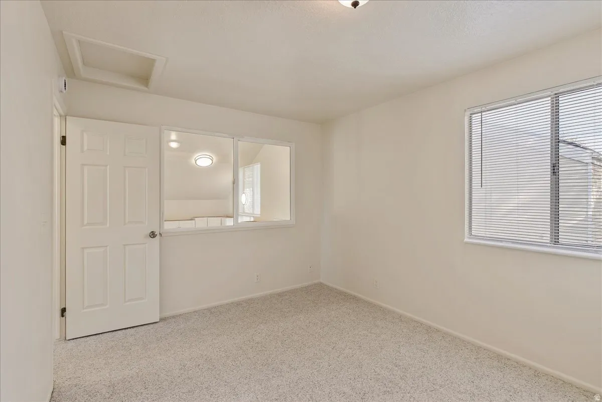 Unfurnished room featuring light colored carpet and healthy amount of natural light