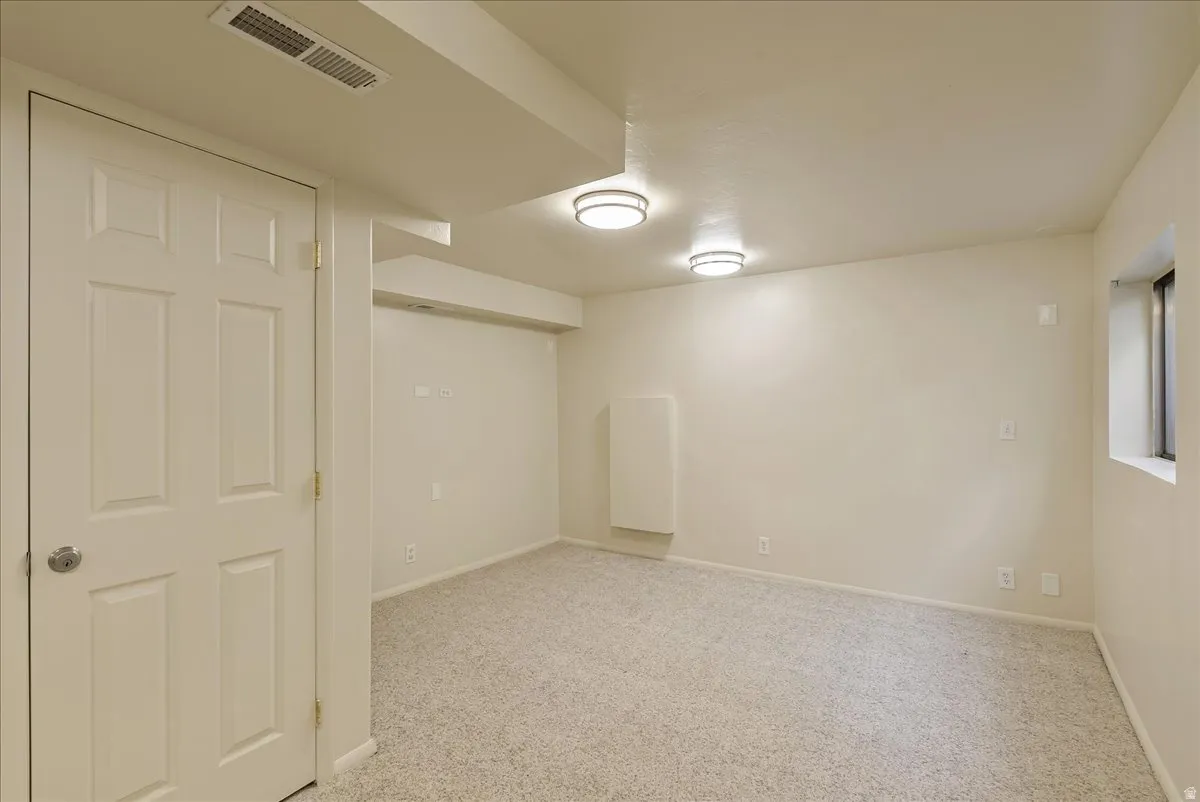 Finished below grade area featuring light carpet and baseboards