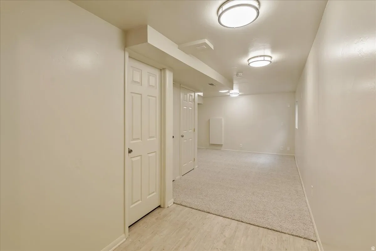 Finished below grade area featuring light wood finished floors and light colored carpet