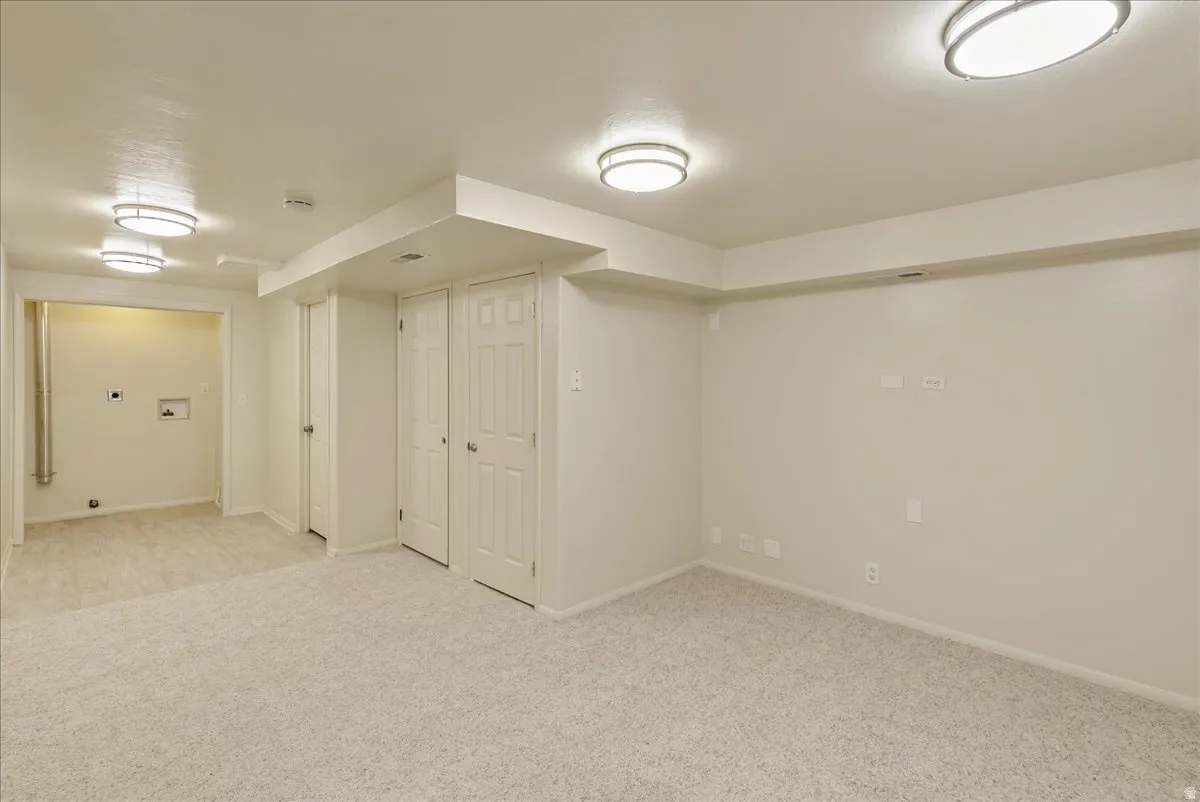 Finished below grade area with baseboards and light colored carpet