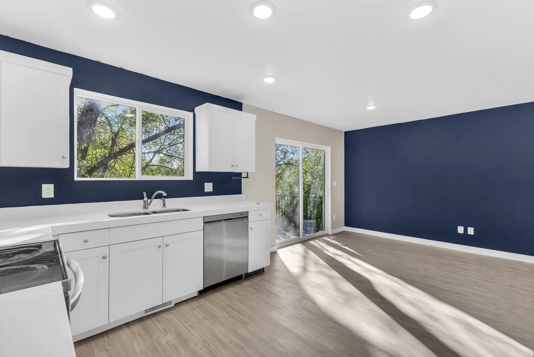 Kitchen with white cabinets, dishwasher, light wood-style floors, range with electric stovetop, and recessed lighting