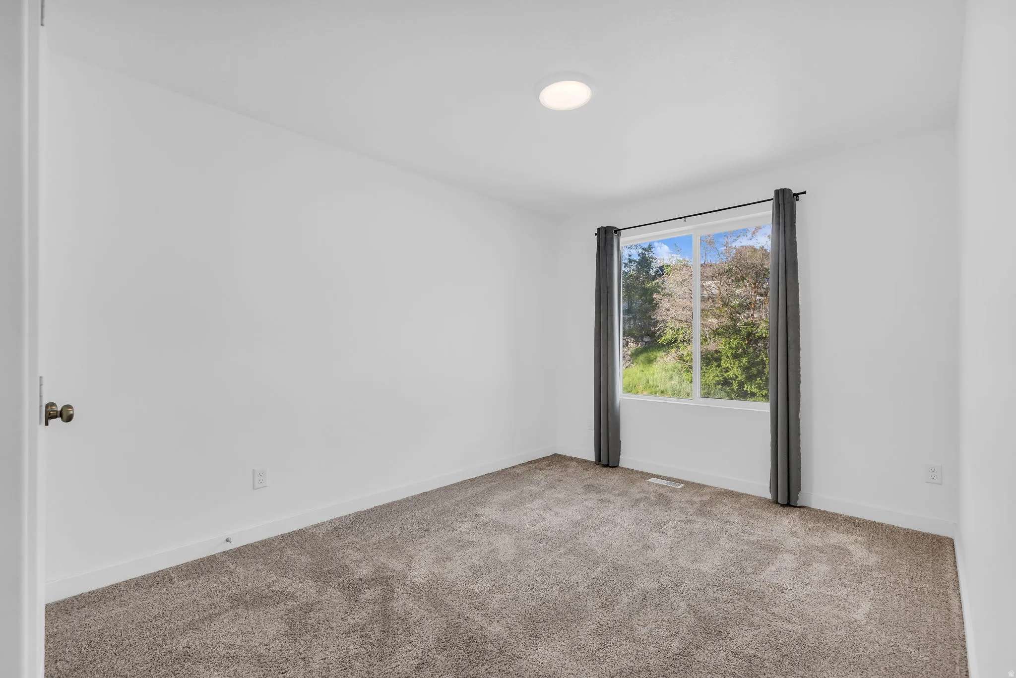 Spare room with carpet and baseboards