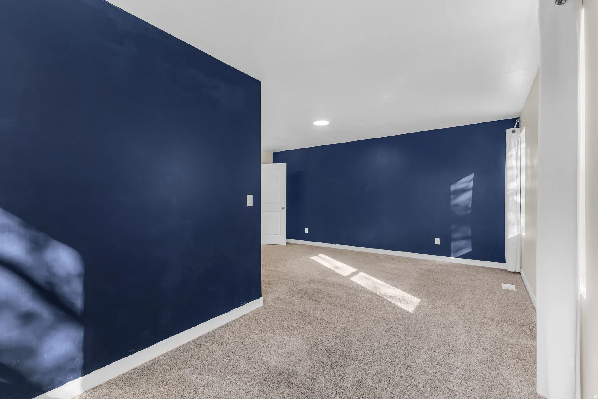 Spare room featuring light colored carpet and recessed lighting