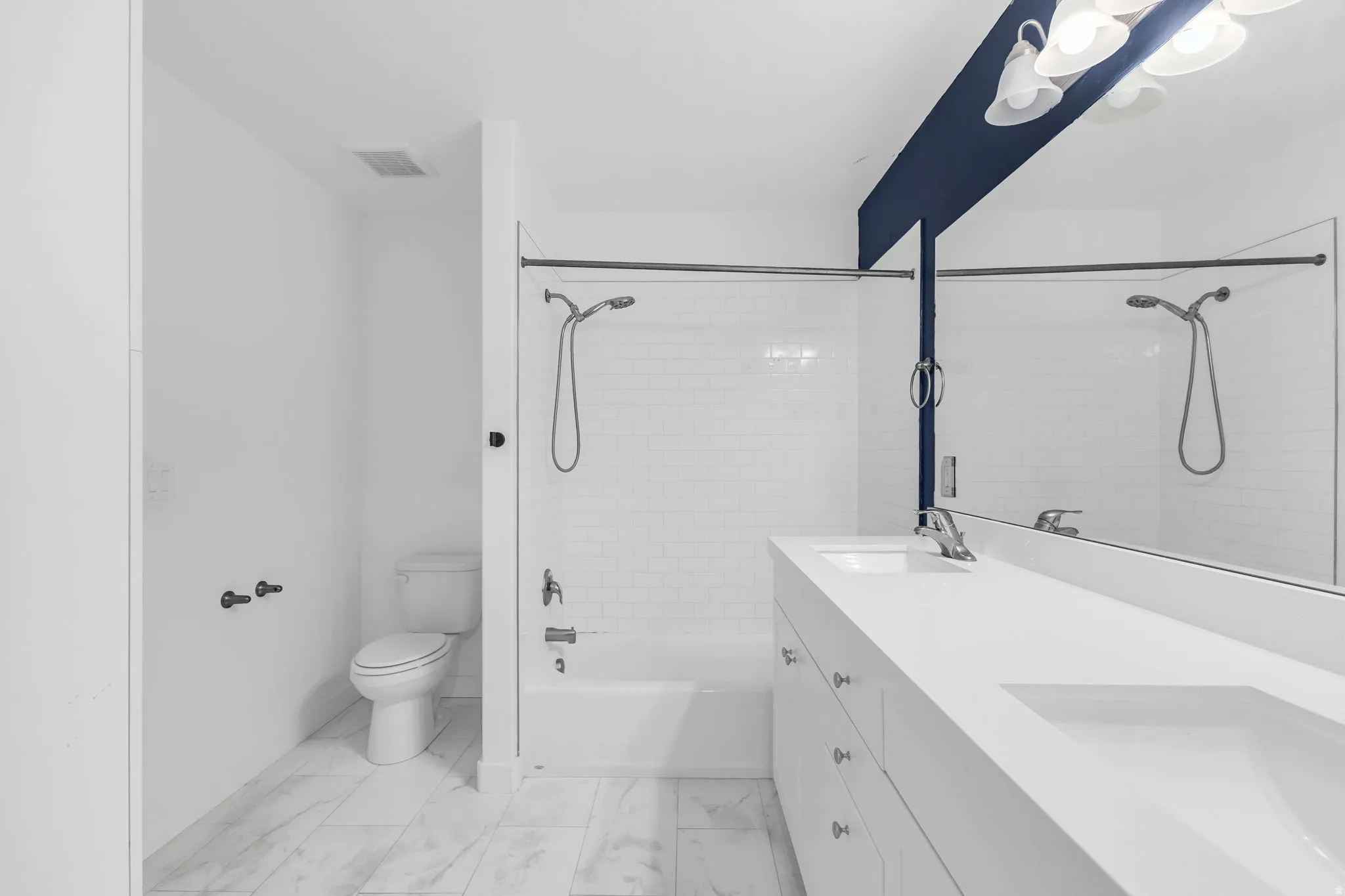 Bathroom featuring double vanity and shower / washtub combination
