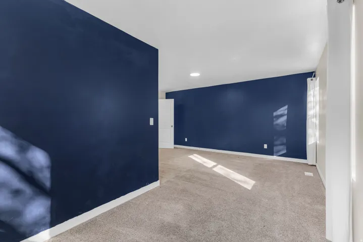 Spare room featuring light colored carpet and recessed lighting