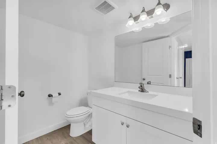 Half bathroom with vanity and light wood-style flooring