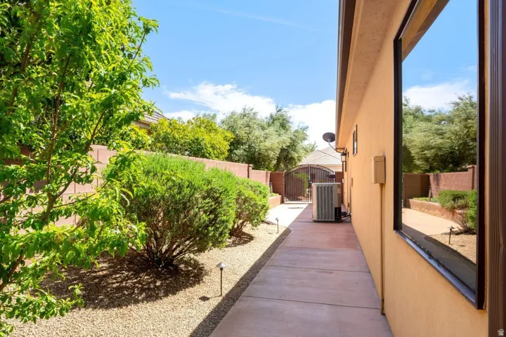 View of side of property featuring a fenced backyard and a gate