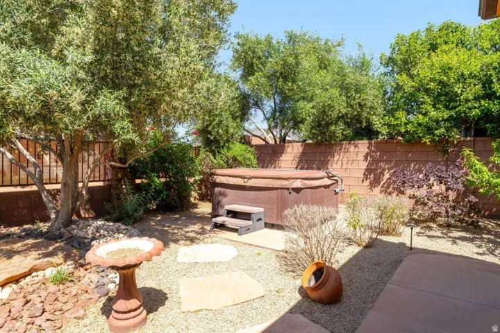 Fenced backyard featuring a patio area and a hot tub