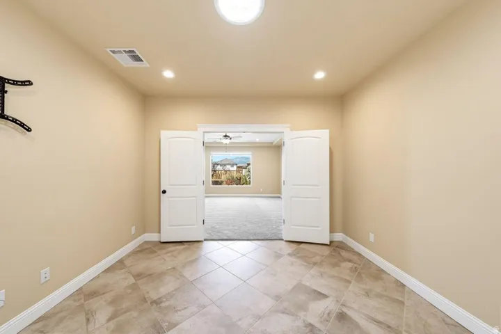 Spare room featuring light tile patterned floors, light carpet, and recessed lighting