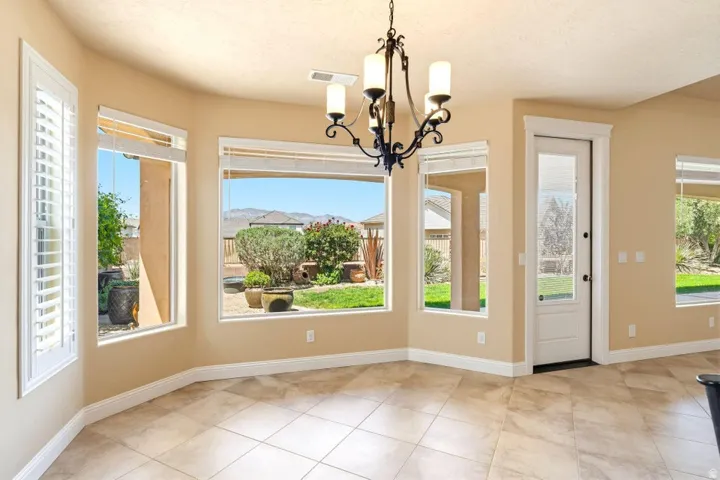 Unfurnished dining area featuring hanging lights and light tile patterned floors