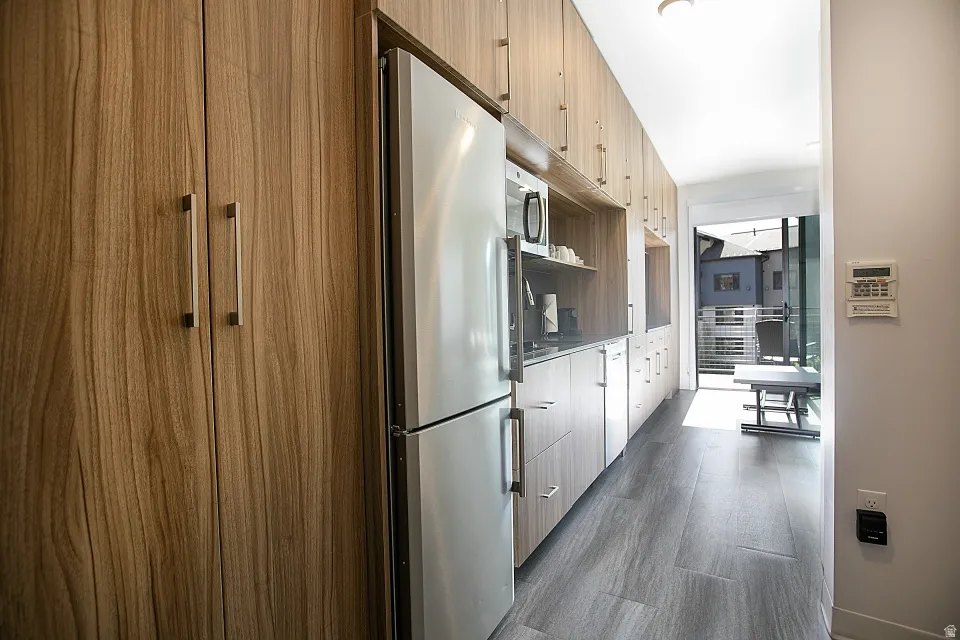 Kitchen with stainless steel appliances, dark wood-style floors, and modern cabinets