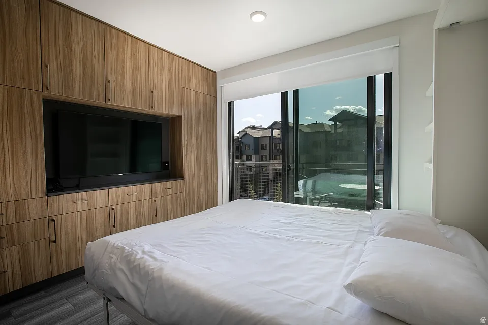 Bedroom with access to exterior and dark wood-style floors