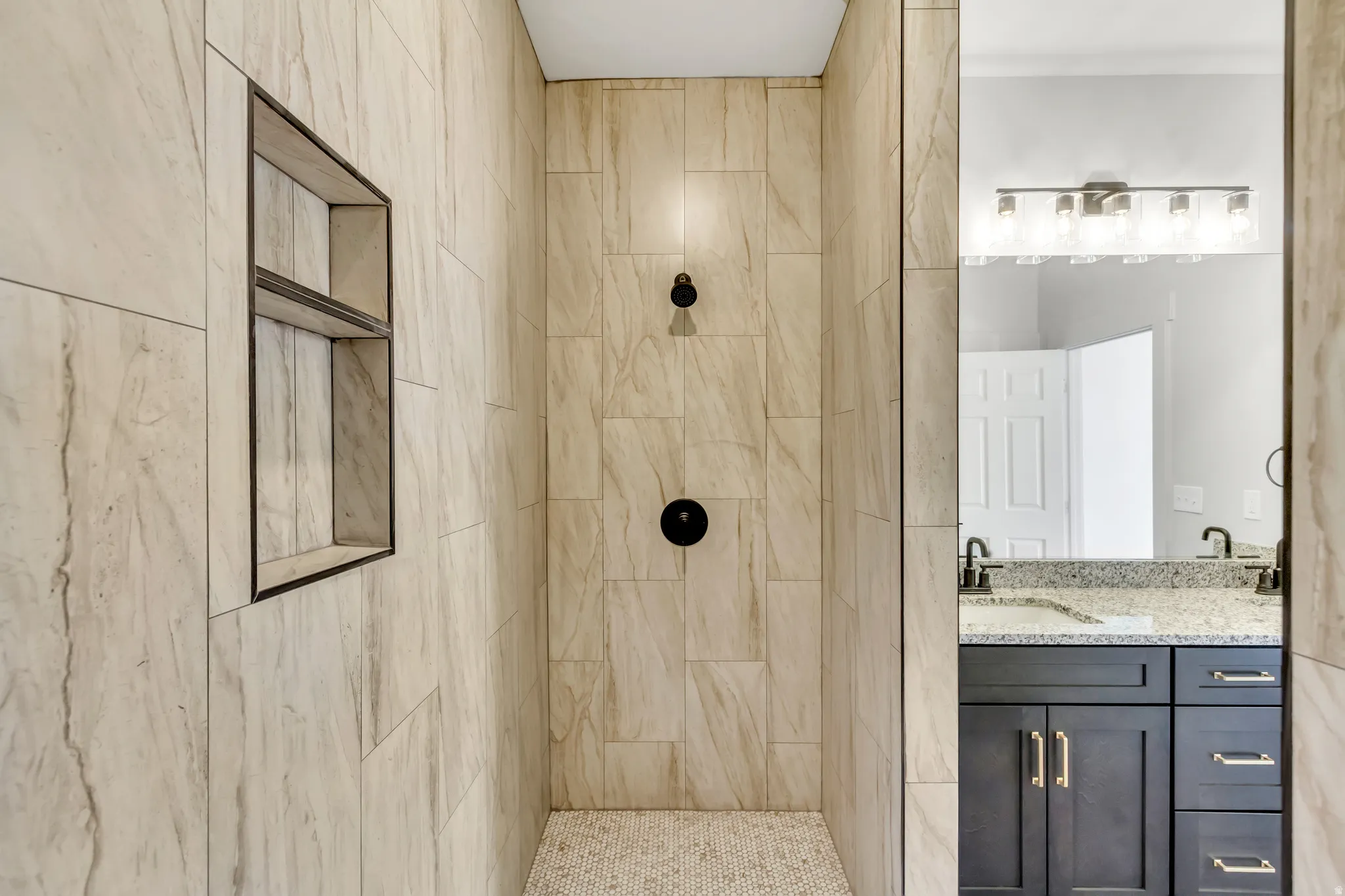 Bathroom with vanity and a tile shower