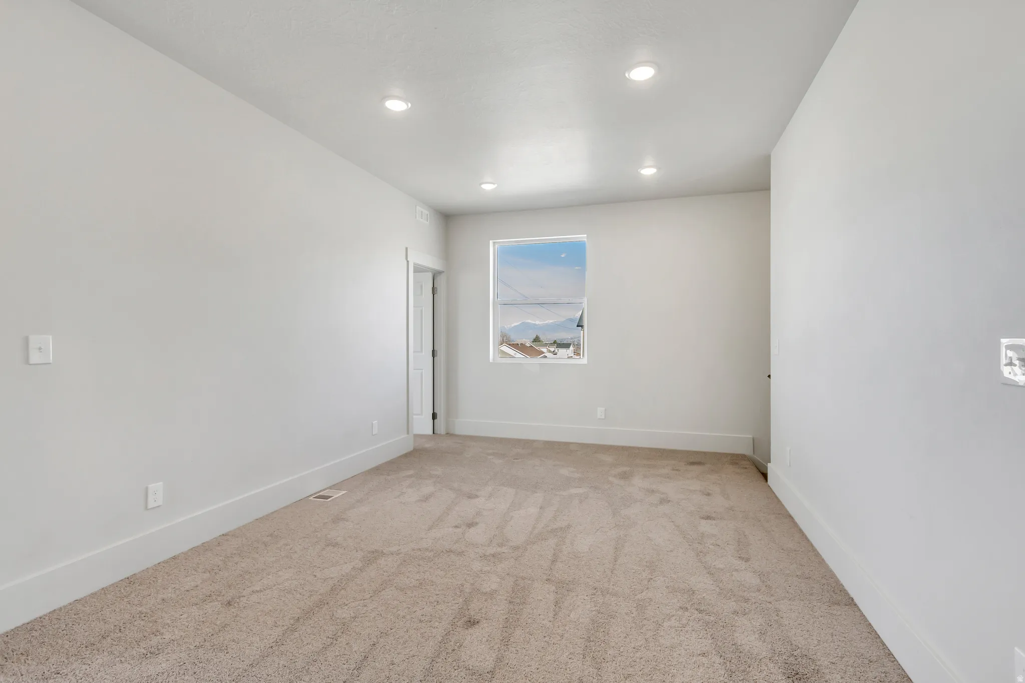 Spare room featuring light carpet and recessed lighting