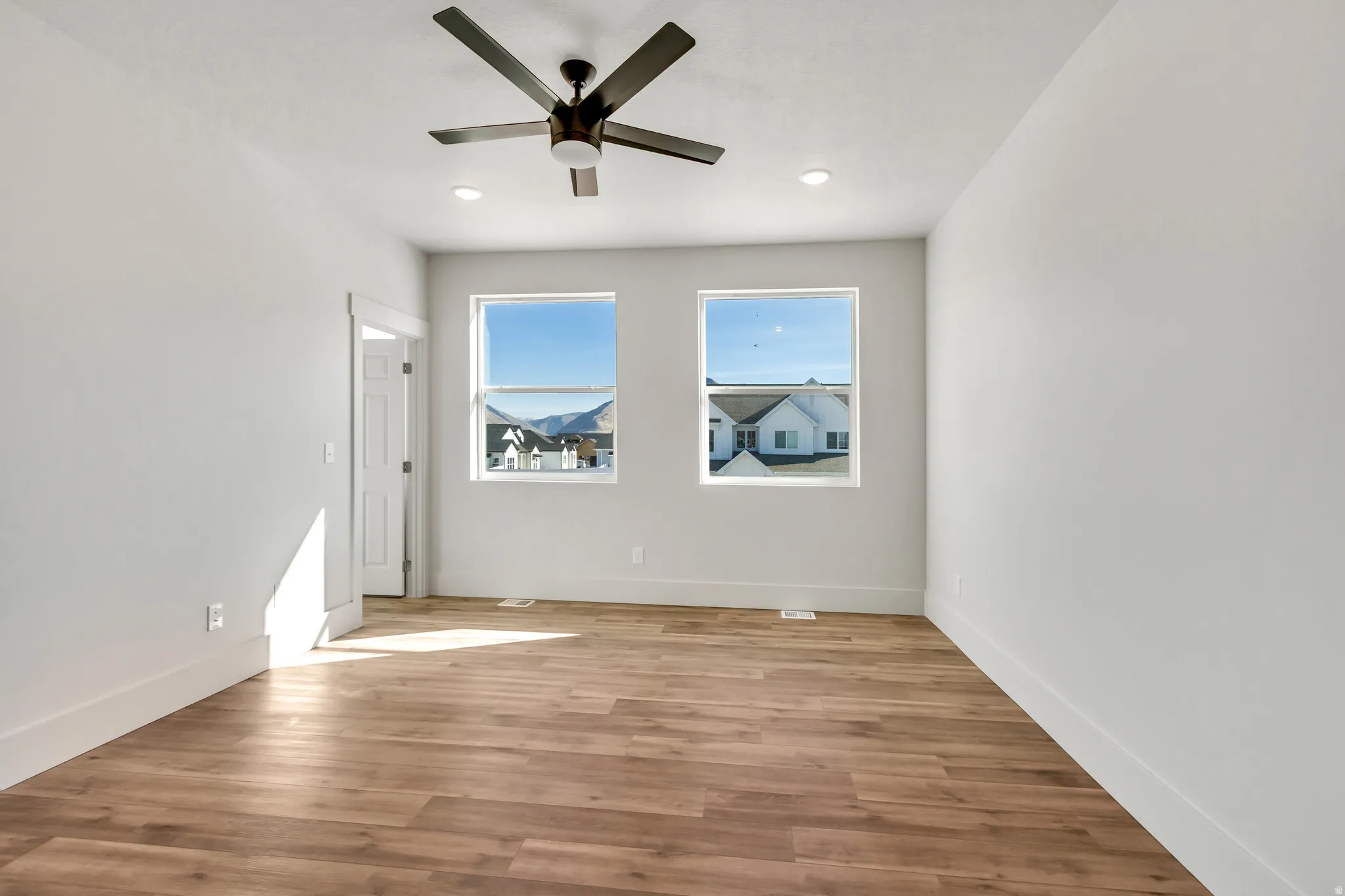 Unfurnished room with light wood-type flooring, ceiling fan, and recessed lighting