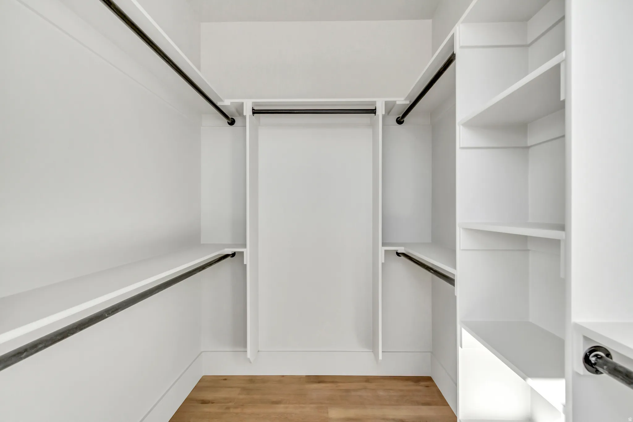 Walk in closet with light wood finished floors