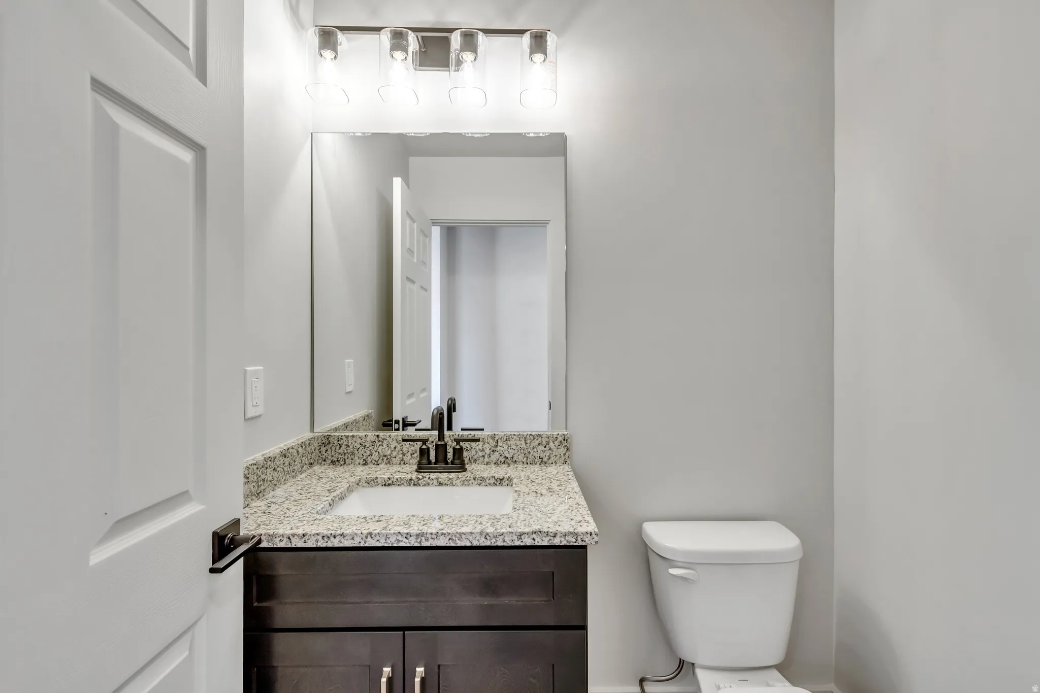 Half bathroom with vanity and toilet