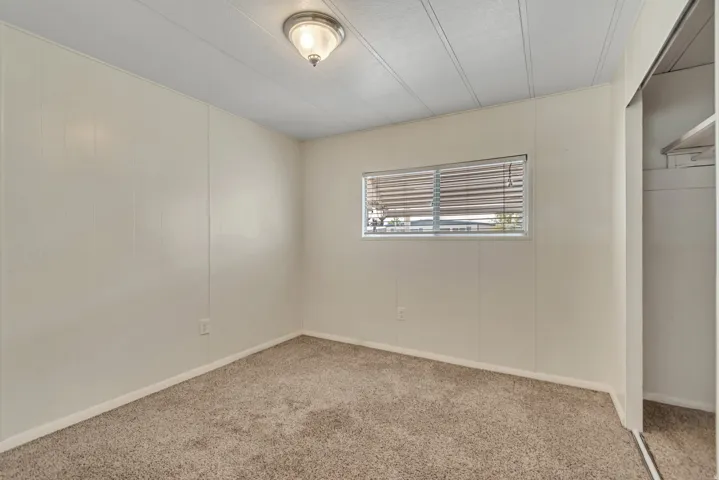 Unfurnished bedroom with carpet flooring and a decorative wall