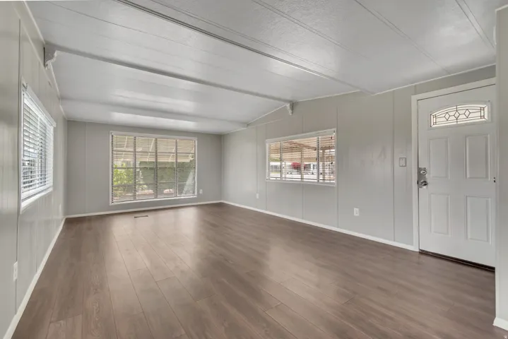 Entrance foyer featuring dark wood-style flooring and vaulted ceiling with beams