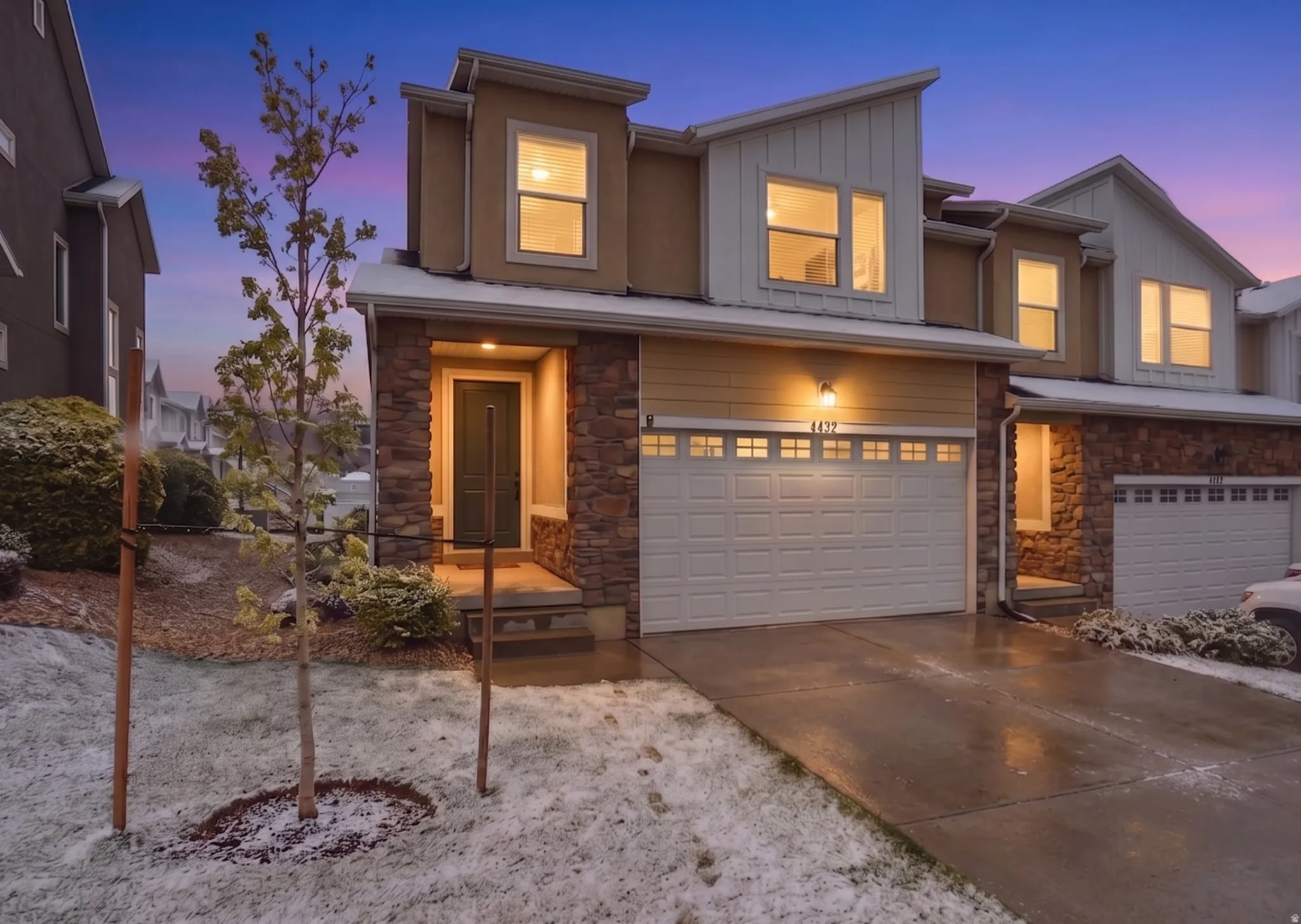 View of front of house featuring stone siding, a garage, board and batten siding, and concrete driveway